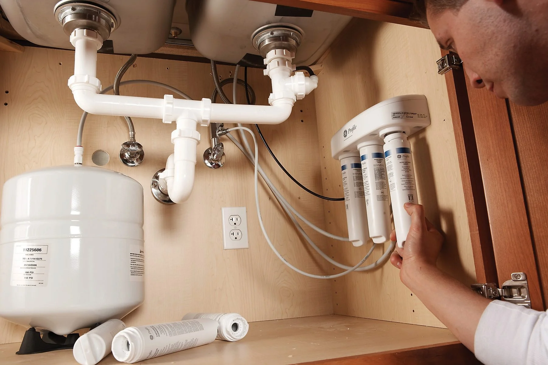 Man installing reverse osmosis water filter.