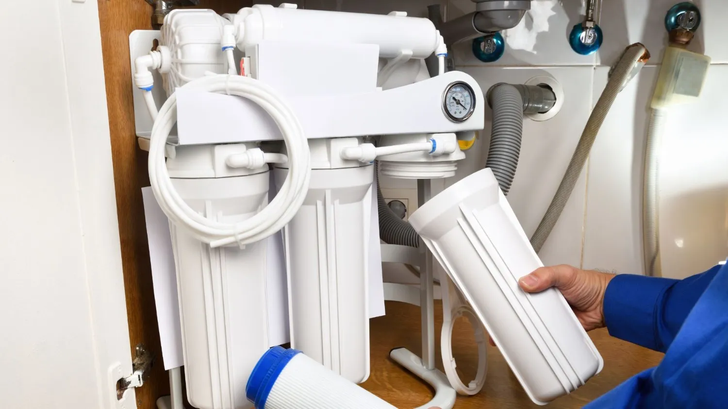 Man changing filters on RO system.