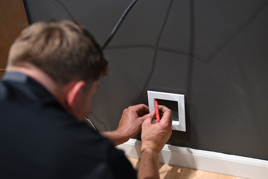 A certified technician carefully wiring a new smart thermostat to a wall mount, showing precision and attention to detail. - smart thermostat installation ventura county