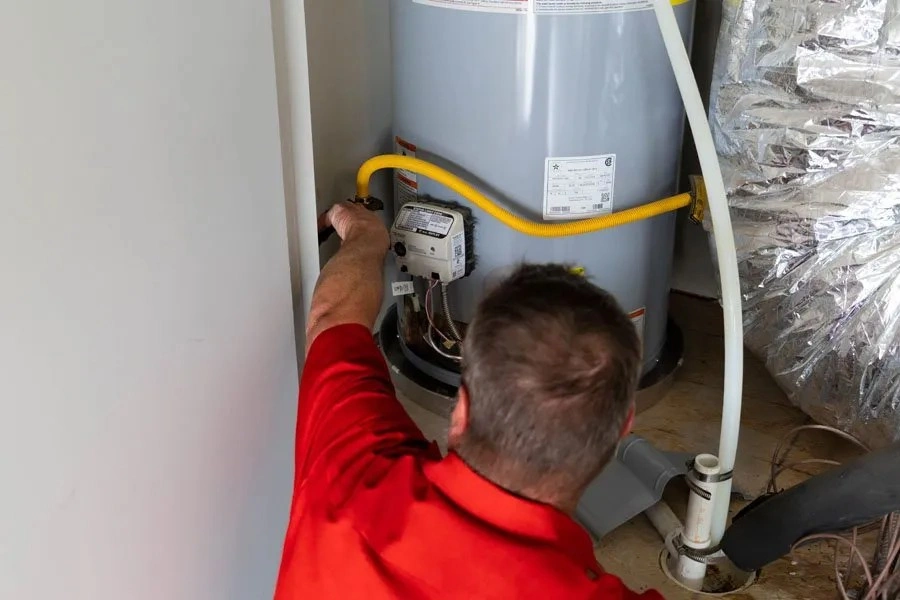 Professional plumber inspecting gas water heater.