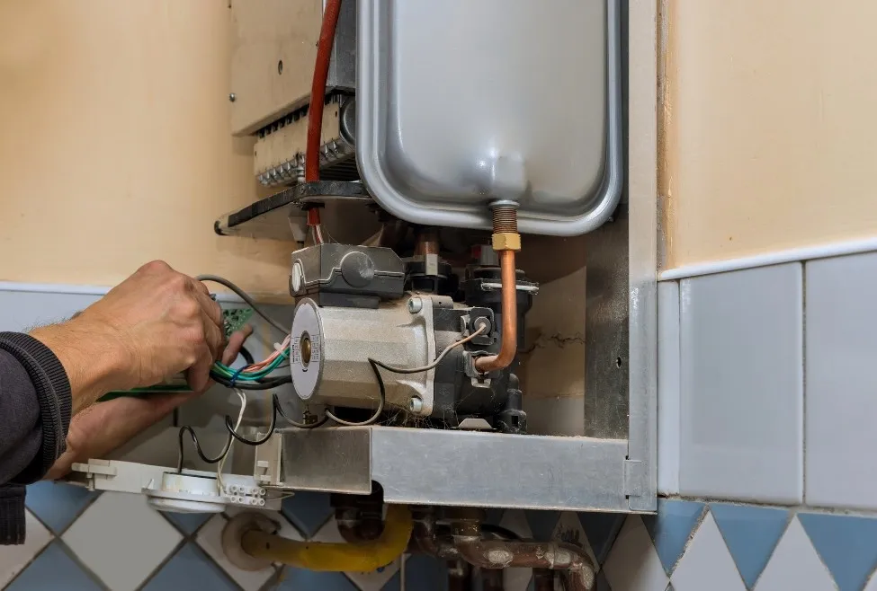 Plumber installing a wall-mounted water heater.