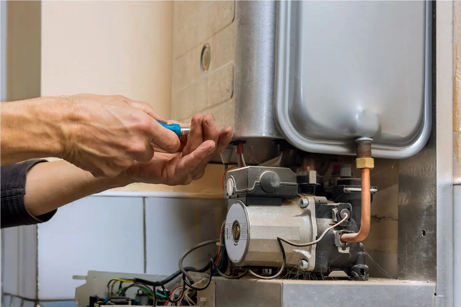 Screwdriver adjusting internal water heater pump.