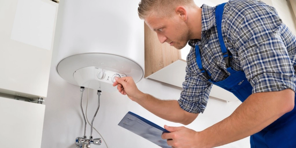 Technician adjusting dial on water heater.