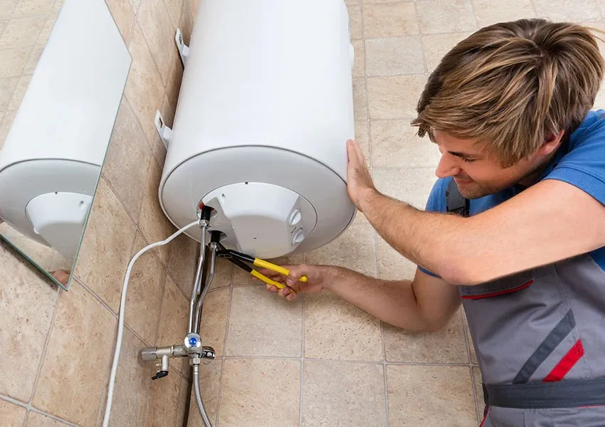 Technician using pliers on electric boiler.