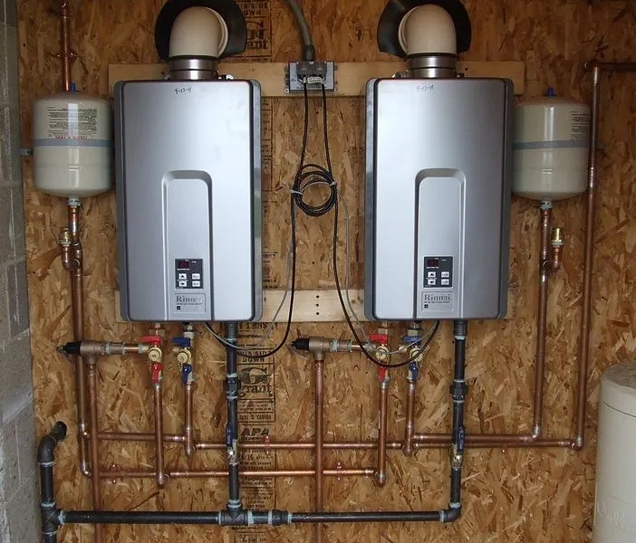White tankless water heater installed outdoors.