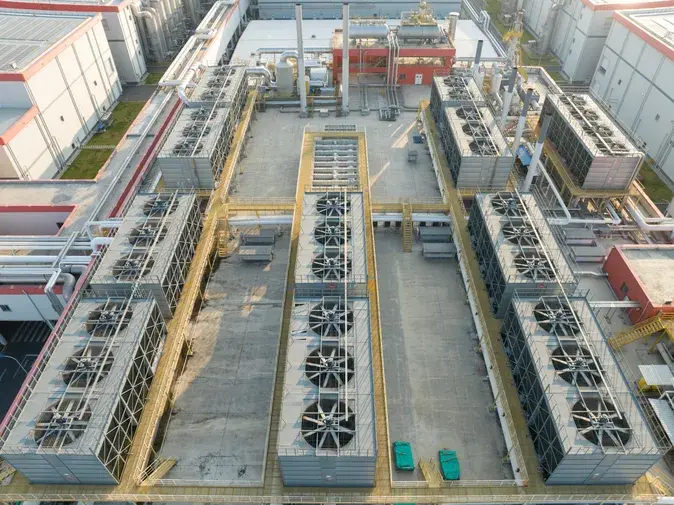 Aerial view of a commercial rooftop featuring multiple large industrial cooling units with fans.