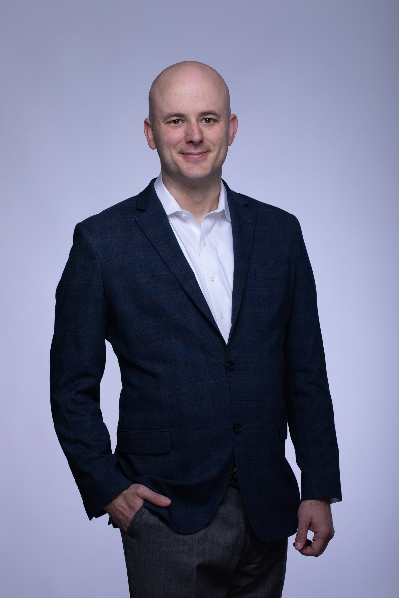 Corporate headshot lit on a seamless backdrop, showing the controlled setup used for consistent team portraits