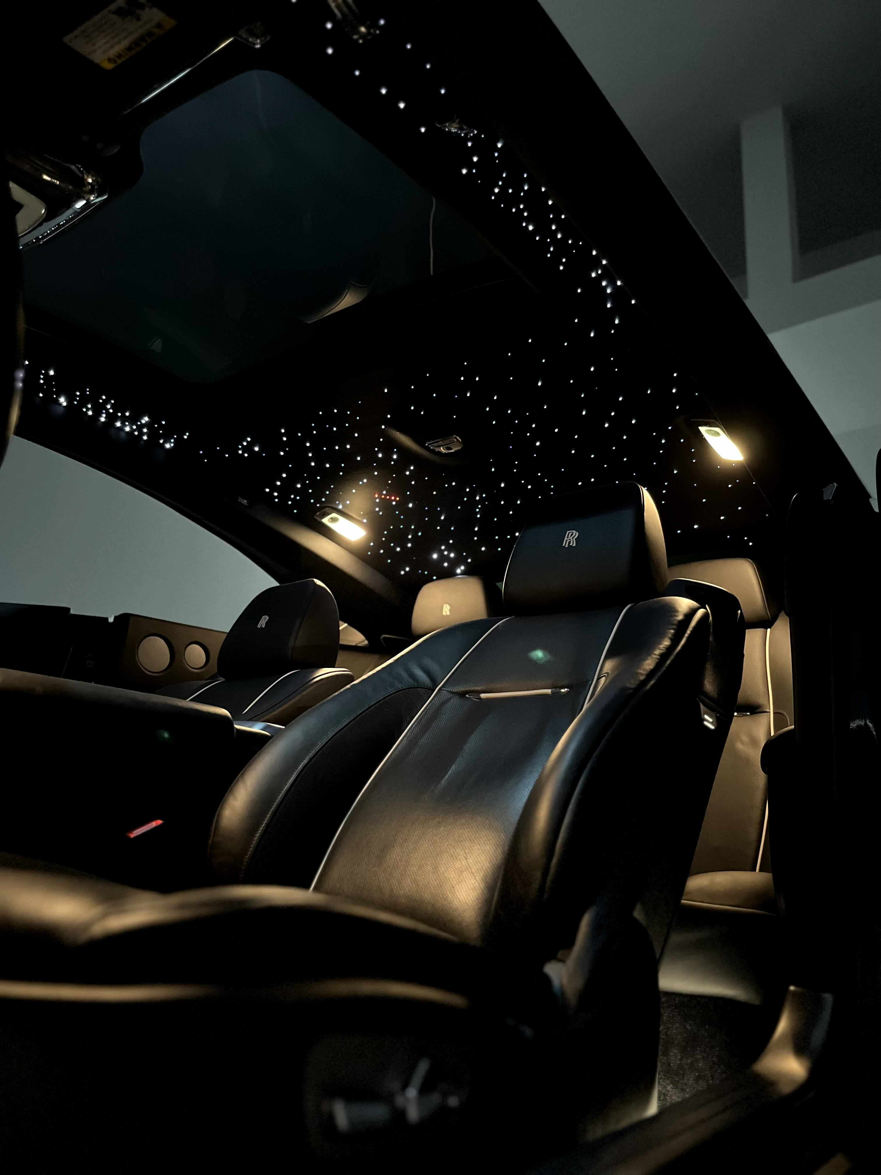 the inside of a car with lights on the ceiling