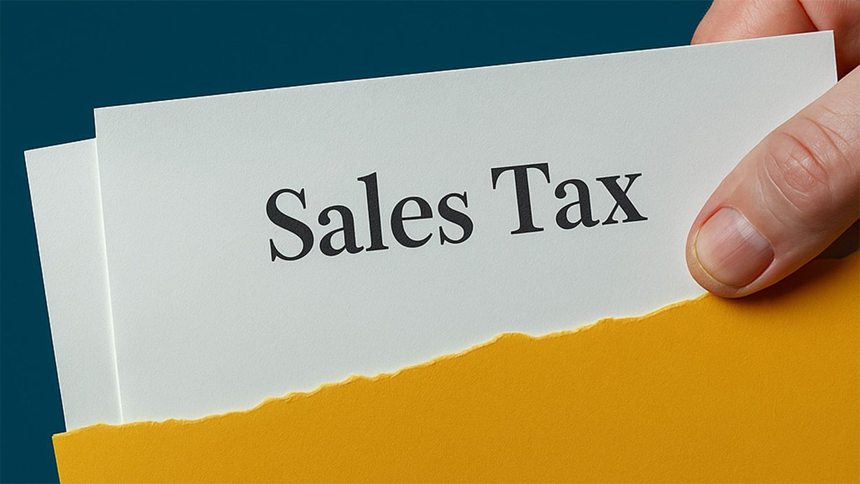 Hand holding a document labeled Sales Tax partly inside a yellow envelope against a blue background