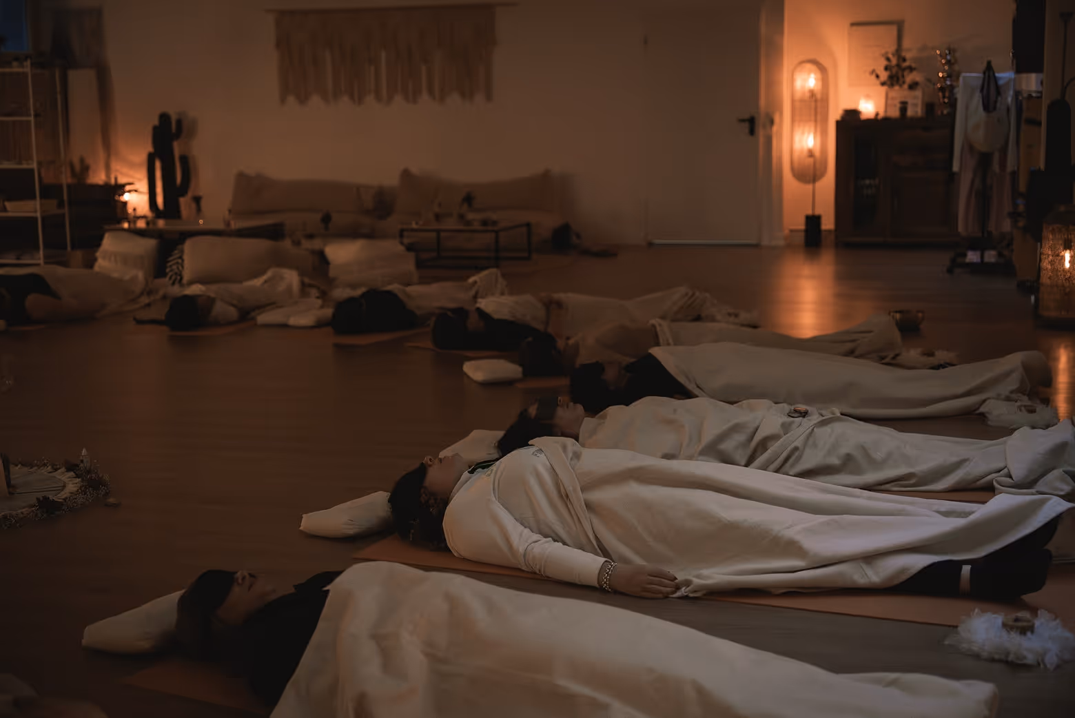 A group of people lying on mats during a guided breathwork session