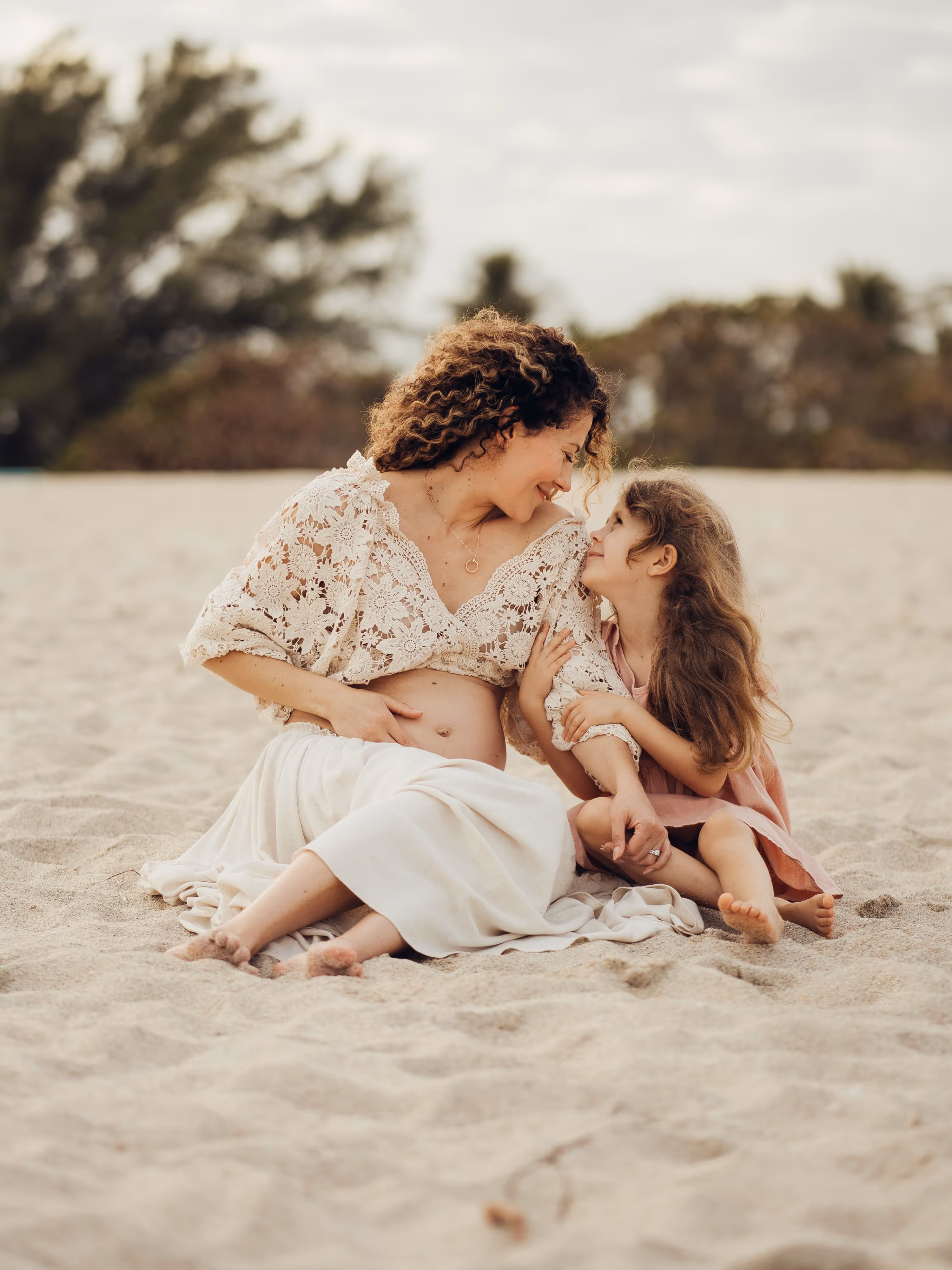 Mother and daughter laying on the beach