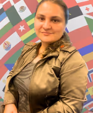 Ms. Farquharson smiling in front of international flags display