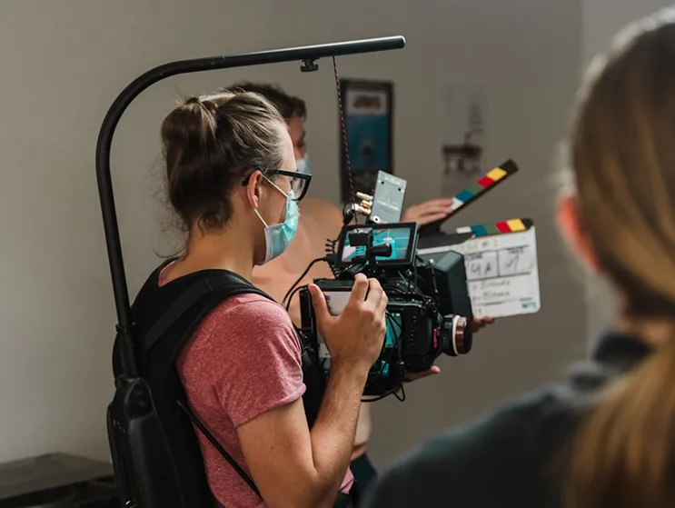 a female photographer carrying an advanced camera in an event 
