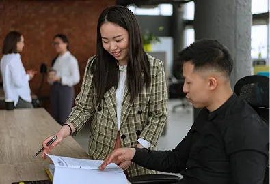 Filipino Man and Woman pointing at a book or document