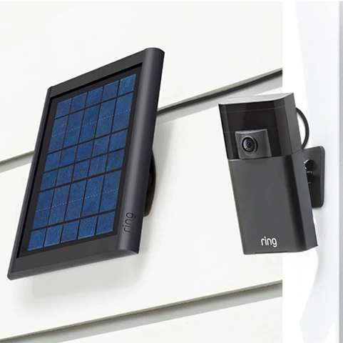 A Ring camera mounted on the wall, next to a solar panel.