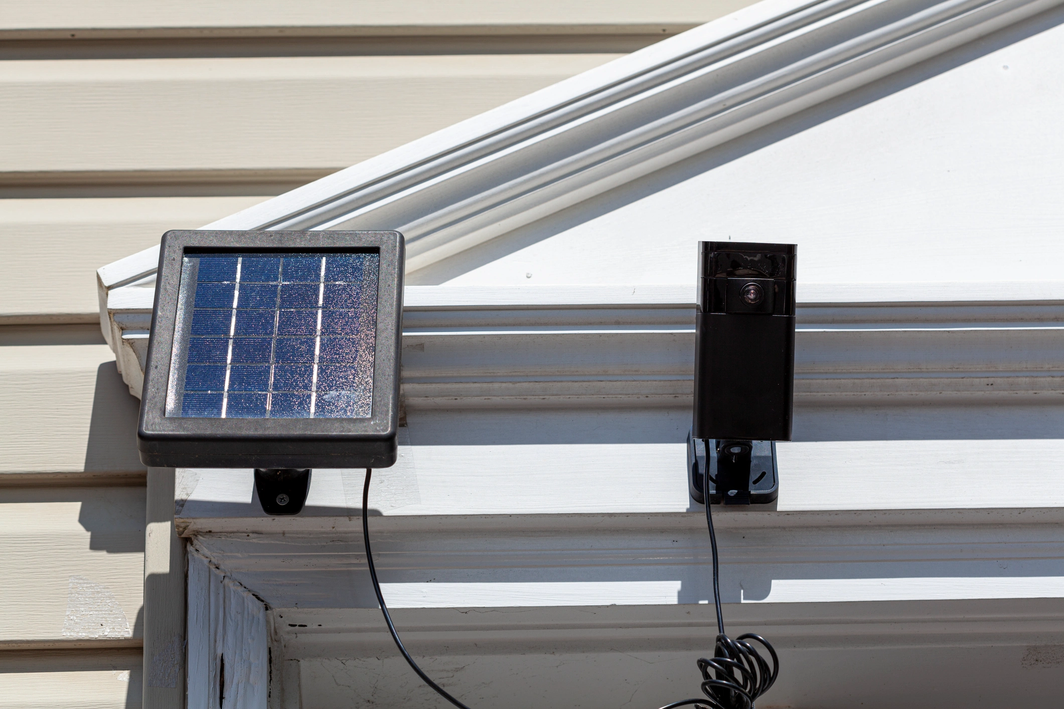 A Ring camera mounted on the wall, next to a solar panel.