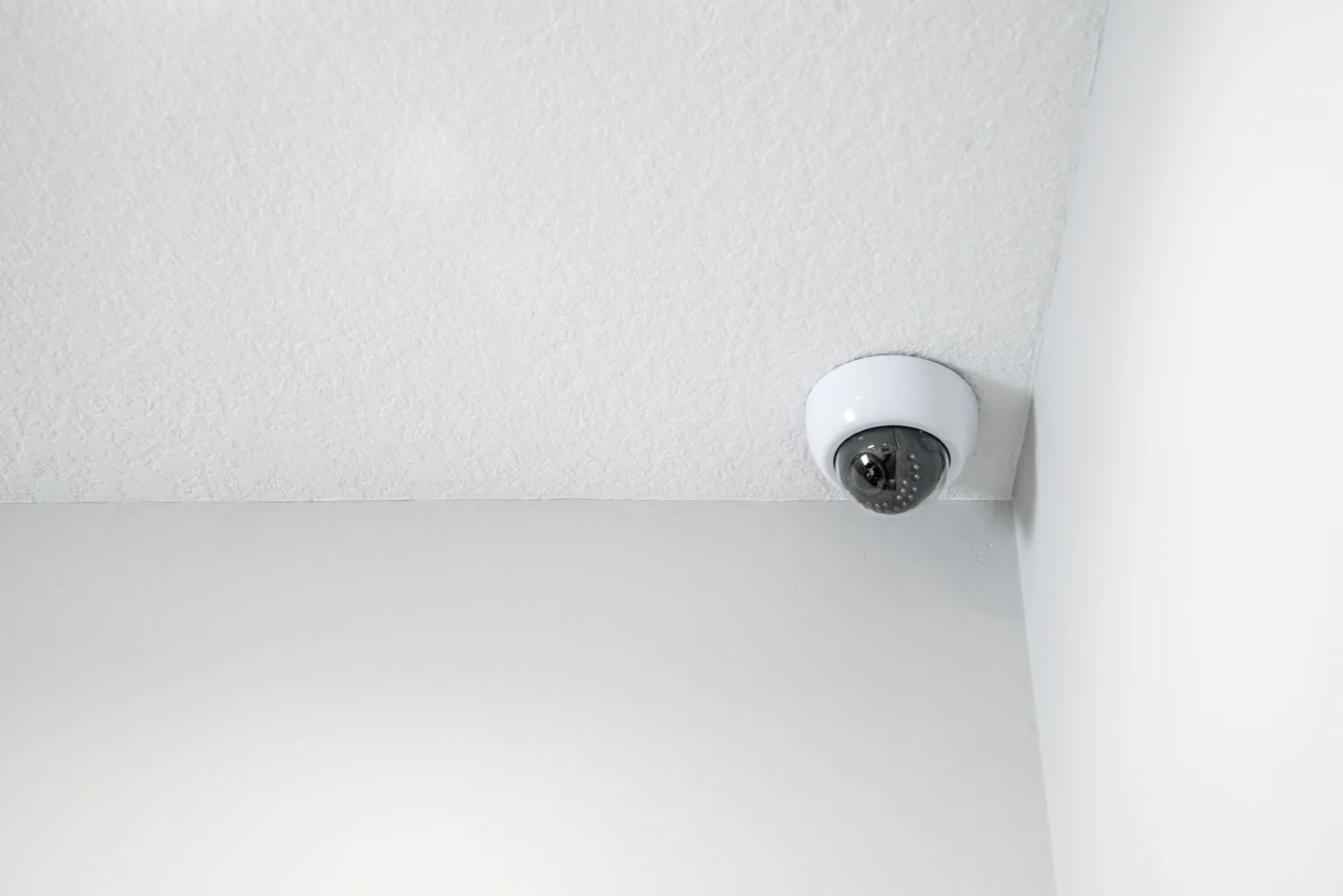 A security camera mounted in the corner of the ceiling.