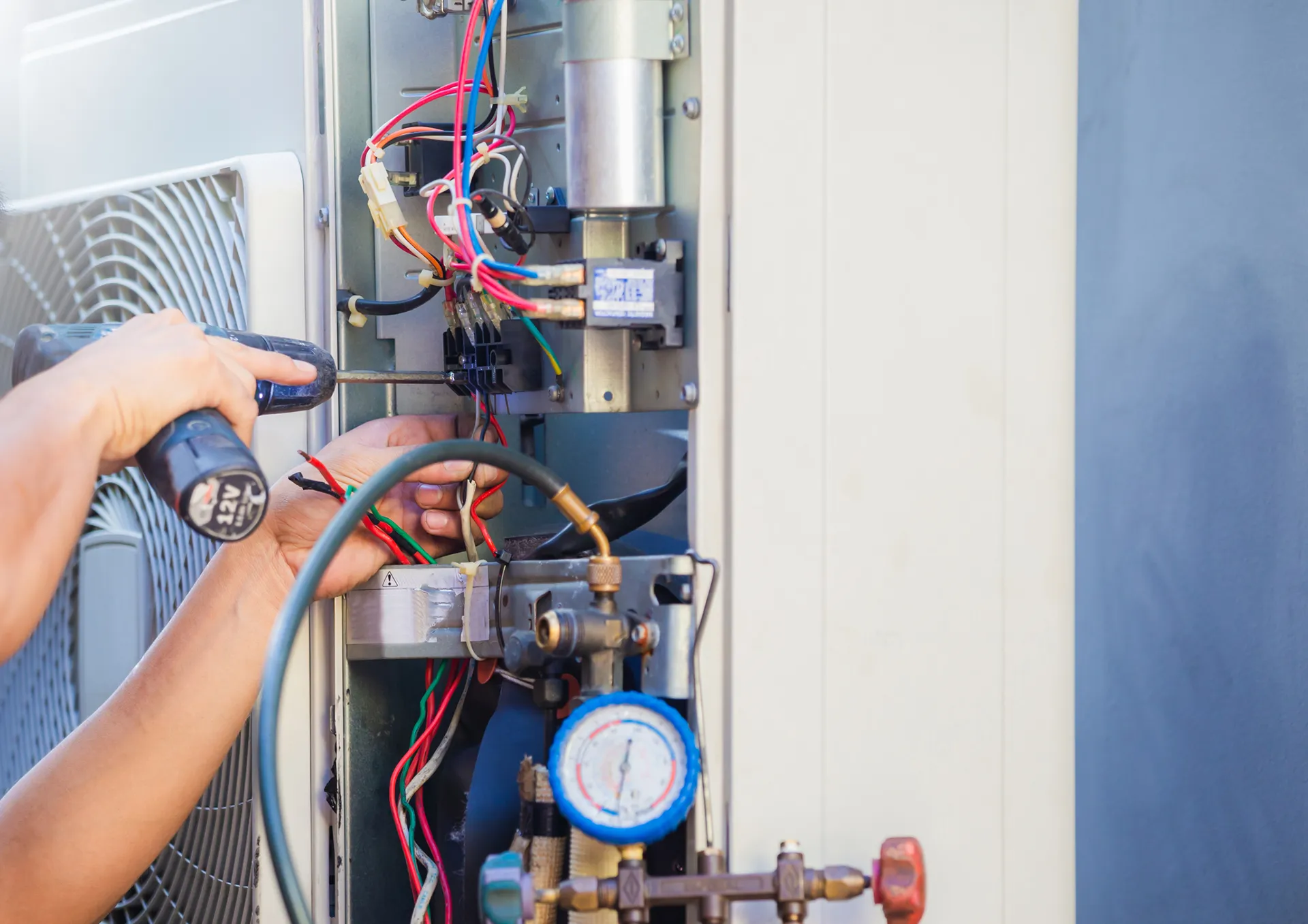 Repairman fixing heat pump electrical wiring.