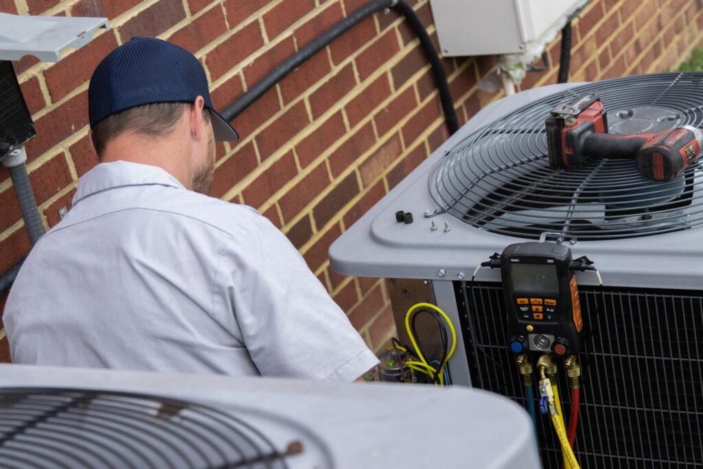 Technician checking Heat Pump unit with gauges.