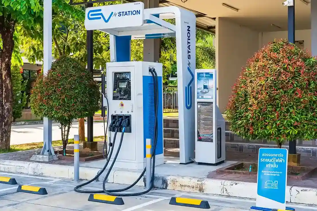Outdoor EV charging station with blue and white power units in a parking lot.