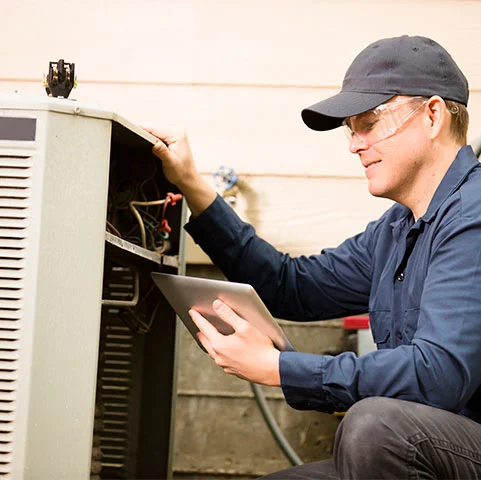 Technician inspecting heat pump unit with tablet, ensuring optimal HVAC performance for energy-efficient climate control in St. Louis Park, MN.