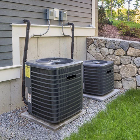 Air conditioning units installed outside a home in Minneapolis, MN, showcasing energy-efficient cooling systems for optimal home comfort.