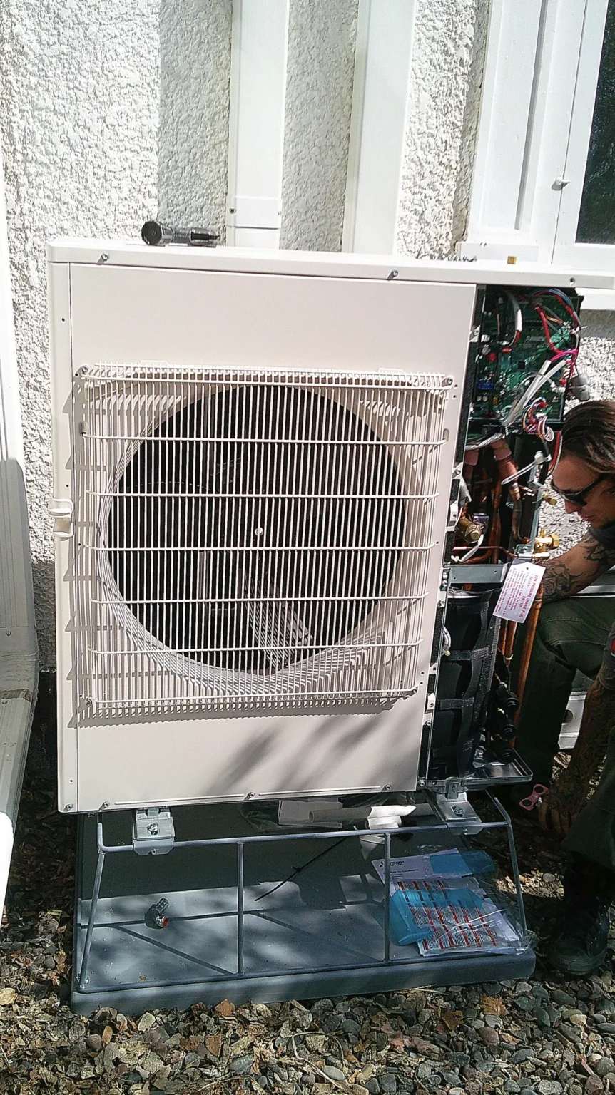 Heat pump installation in Minneapolis, MN, with technician servicing unit outdoors, showcasing HVAC expertise.