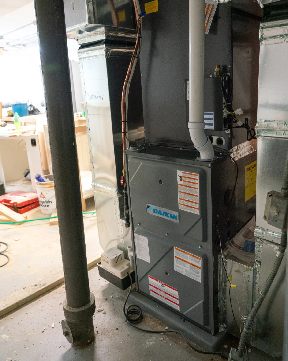 Furnace unit in a basement, featuring Daikin branding, surrounded by ductwork and pipes, illustrating HVAC installation relevant to furnace repair services in Minnetonka, MN.