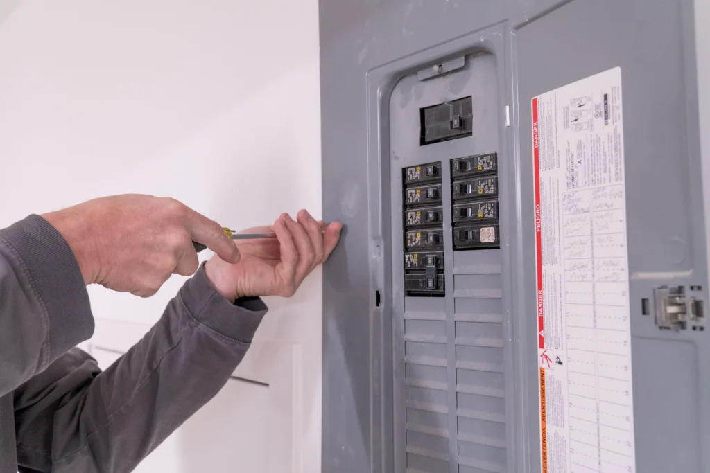 Electrician working on a residential electrical panel, emphasizing installation and repair services in North St. Paul, MN.