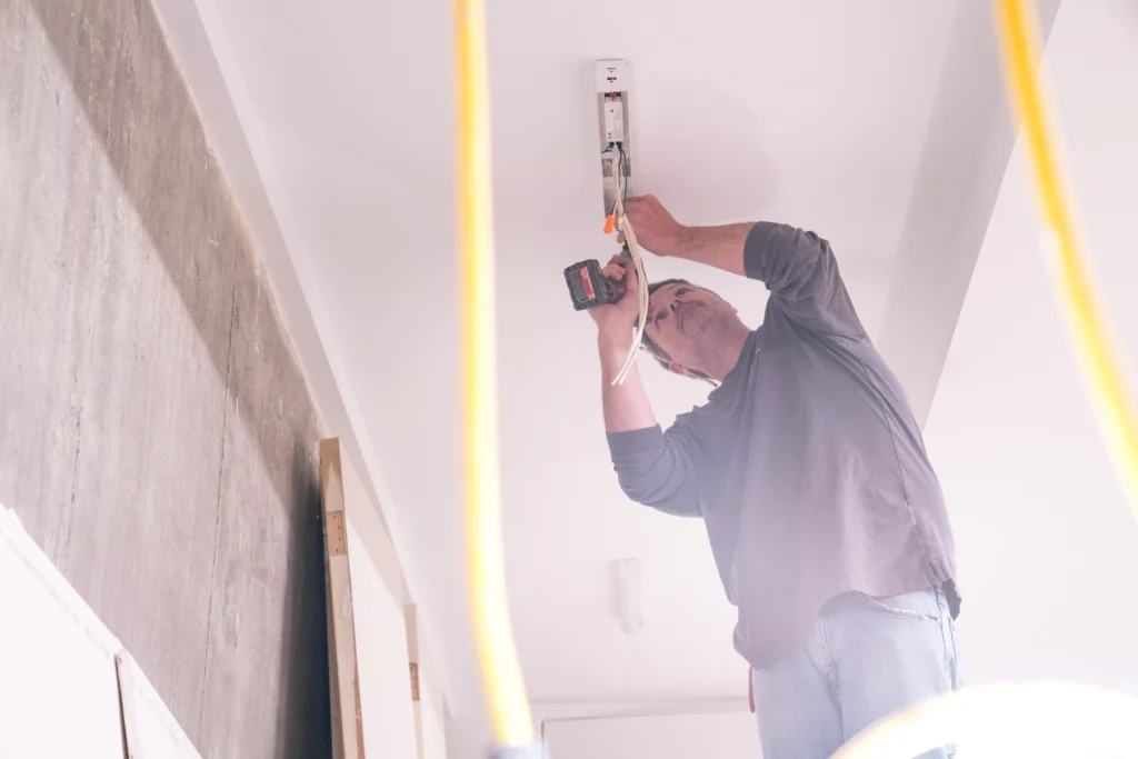 Electrician installing electrical wiring in residential setting, ensuring safe and efficient electrical solutions for home renovation in Prior Lake, MN.