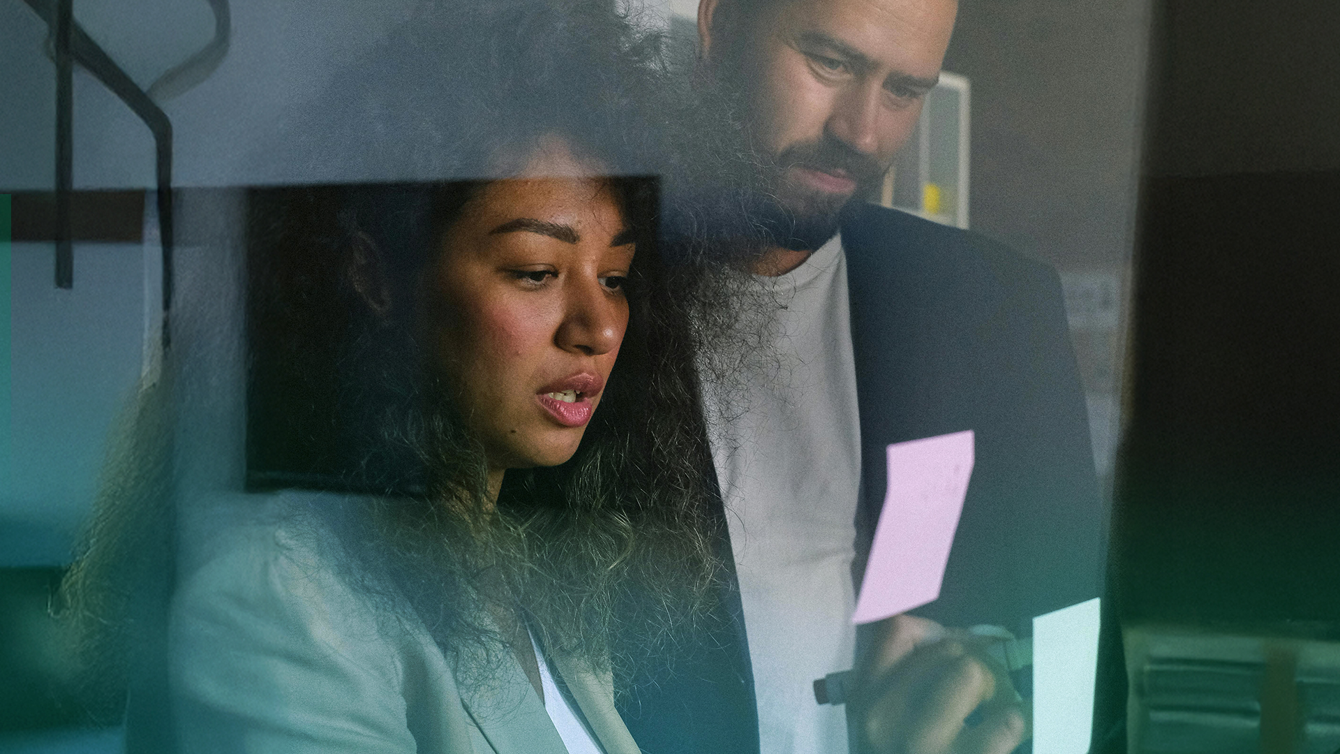 Diverse group of business people standing in a circle with their hands stacked in the center.