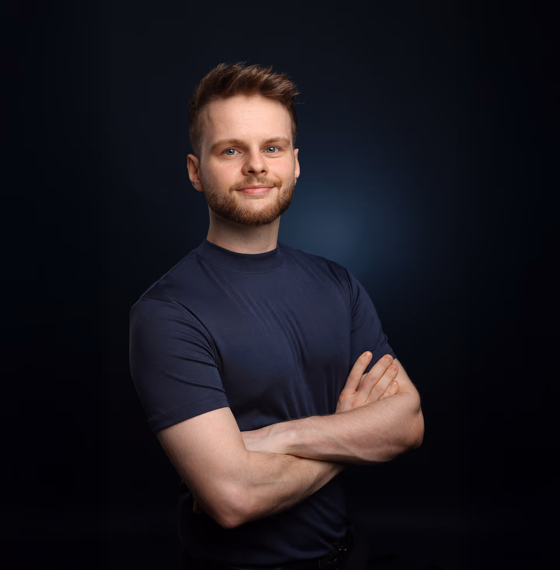 Leon Quiring steht mit verschränkten Armen nach rechts