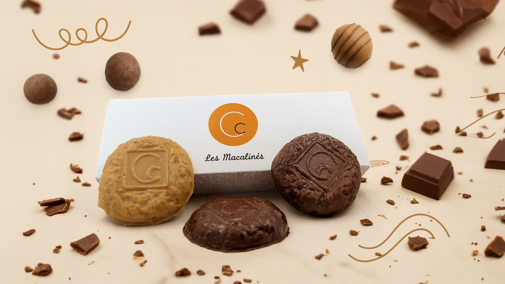 Macalinés, spécialités emblématiques  de la Maison Charrier, présentés sur un fond gourmand avec des éclats de chocolat.