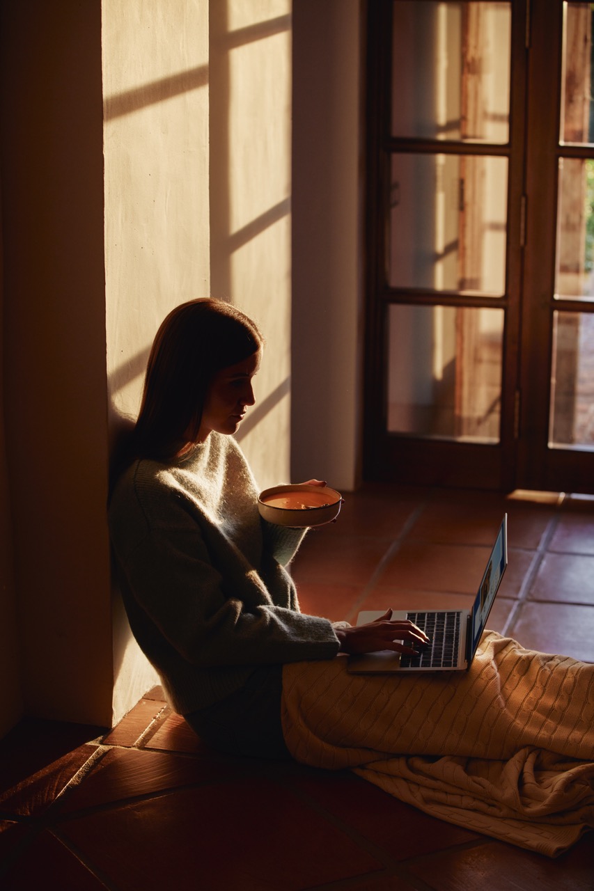 Person typing on a laptop, focusing on business financing articles and resources, with additional screens in the background.