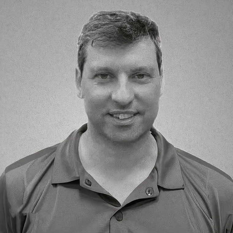Black-and-white portrait of a smiling man in a polo shirt.