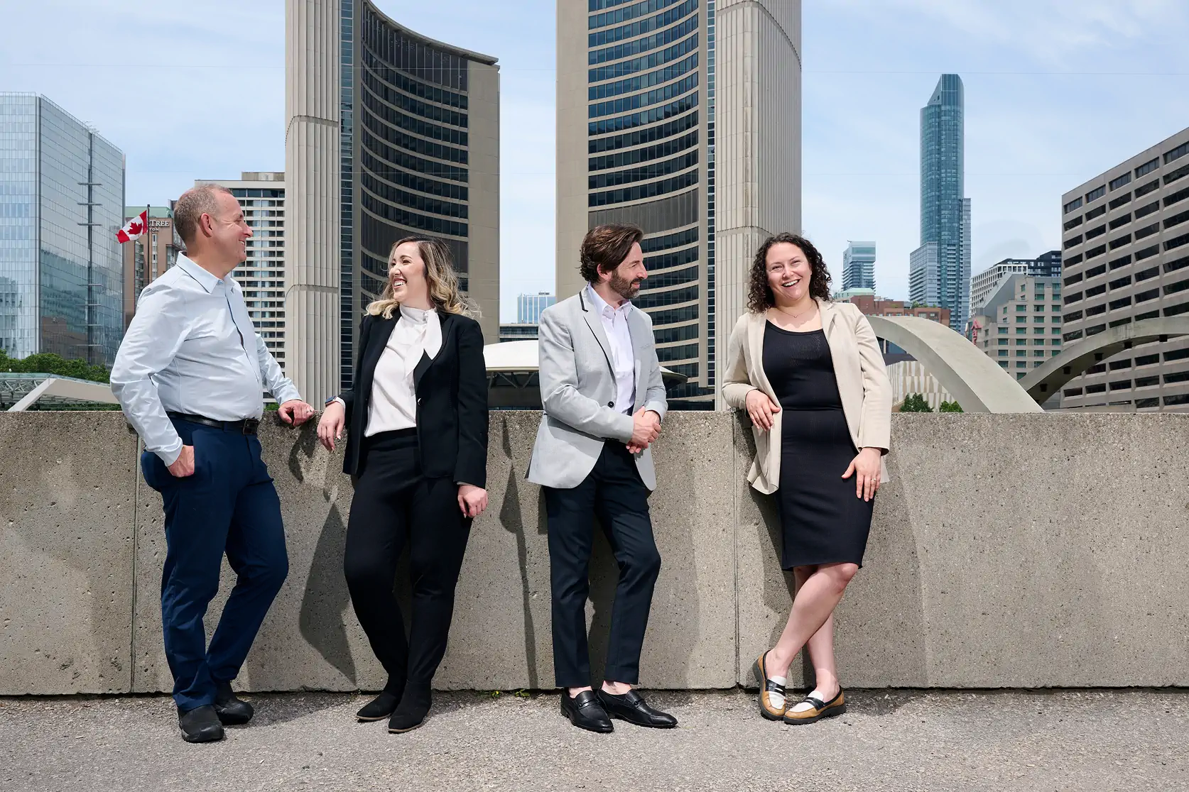 A group of lawyers standing in front of a ledge, facing the Toronto City Hall.