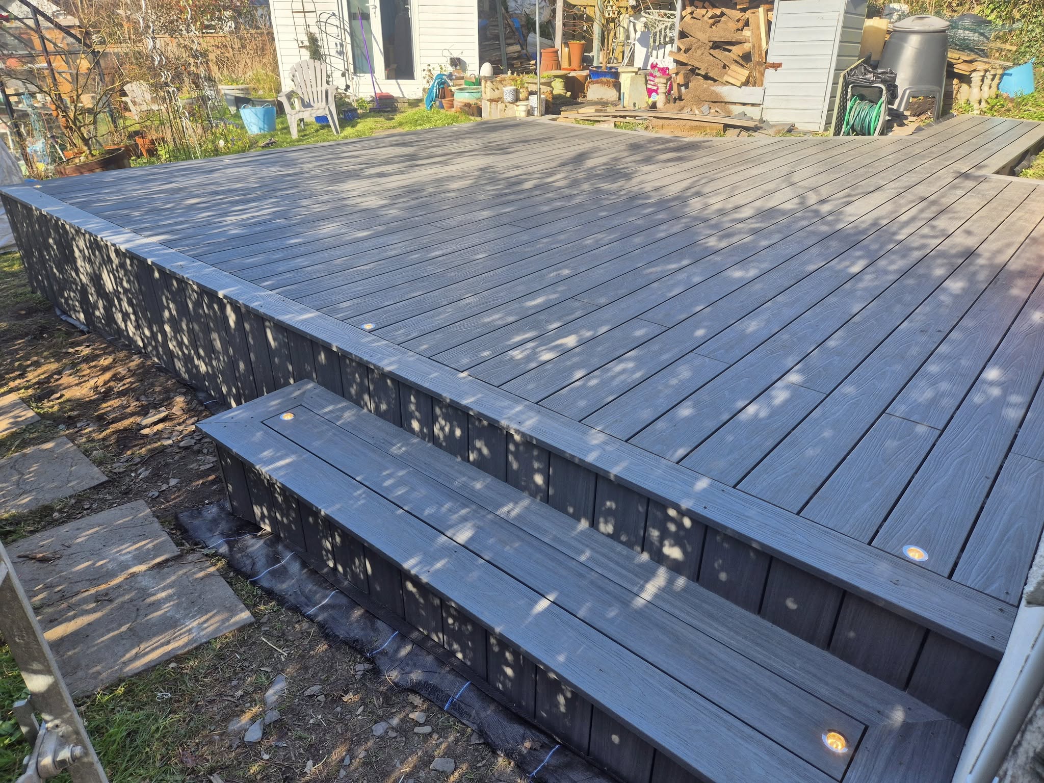 Close-up of grey composite deck boards being installed over the framework.