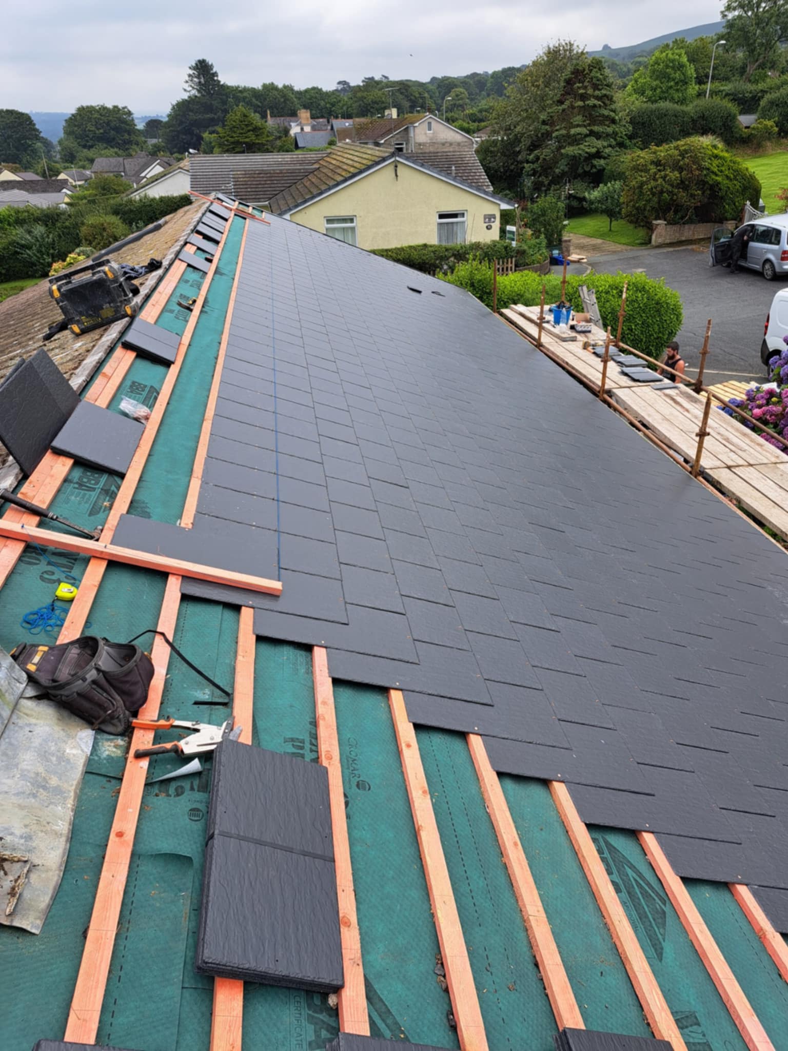 Scaffolding on the side of a house with roof battens in progress.
