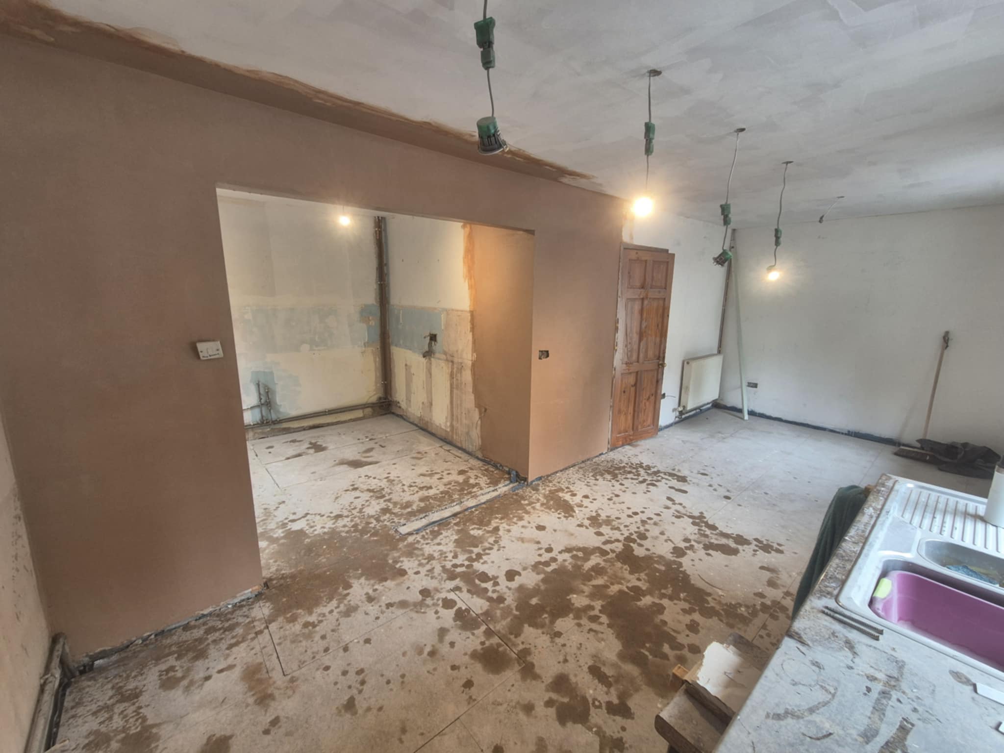 A partially renovated room with exposed walls and tools on the floor.