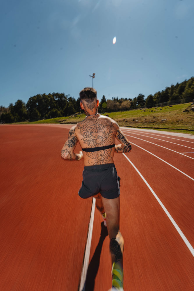 Photographie de Quentin Joly. Coureur de dos sur piste d'athlétisme. 