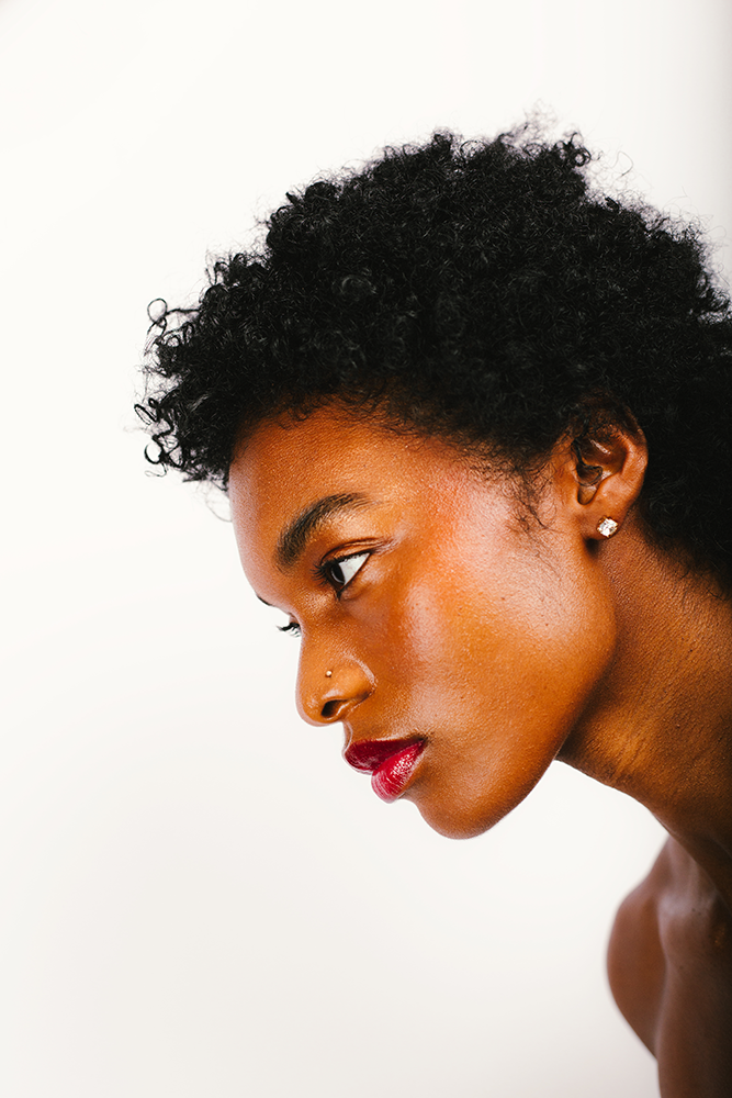 Photographie de Romane Kouo. Portrait d'une femme sur fond blanc.