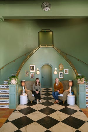 Molly Hall, left, and Elise Taylor sit by the original staircase in what was a Chrysler dealership showroom and now home to The Harvey Bakery and Kitchen.