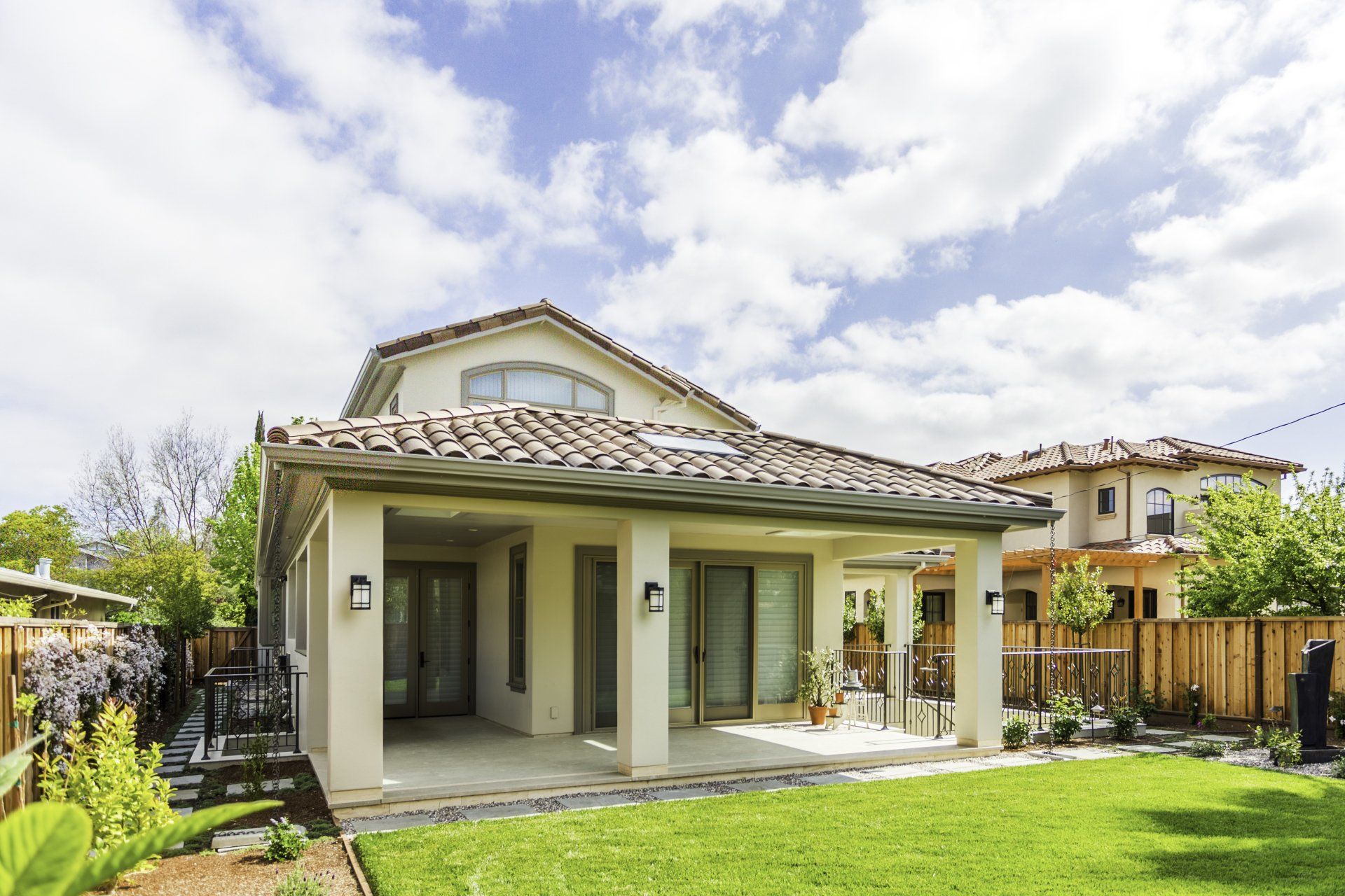 spanish style home with clay shingle roof and stucco siding