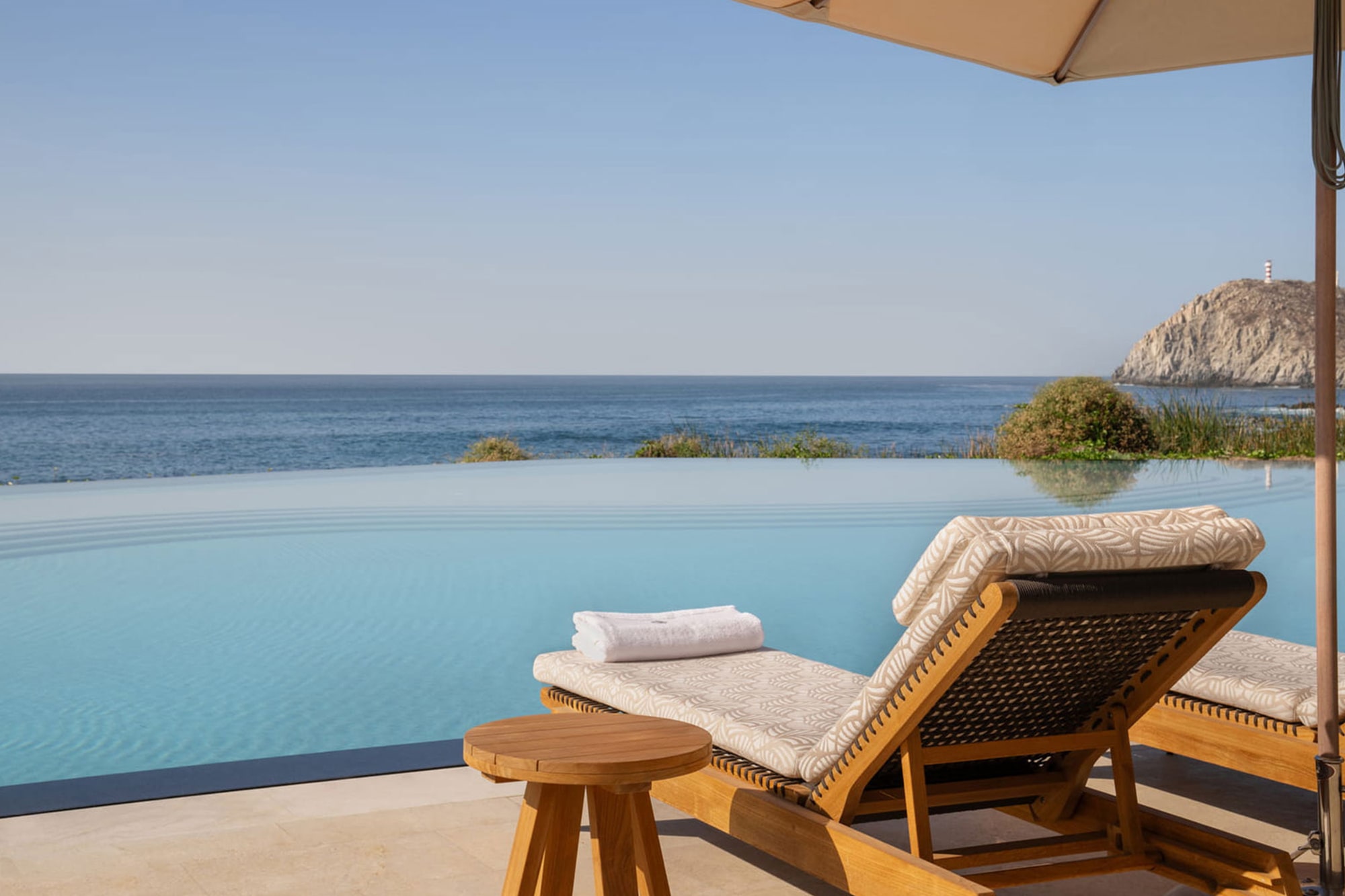 Infinity pool with ocean view and lounge chair at Four Seasons Cabo del Sol, represented by Terentti
