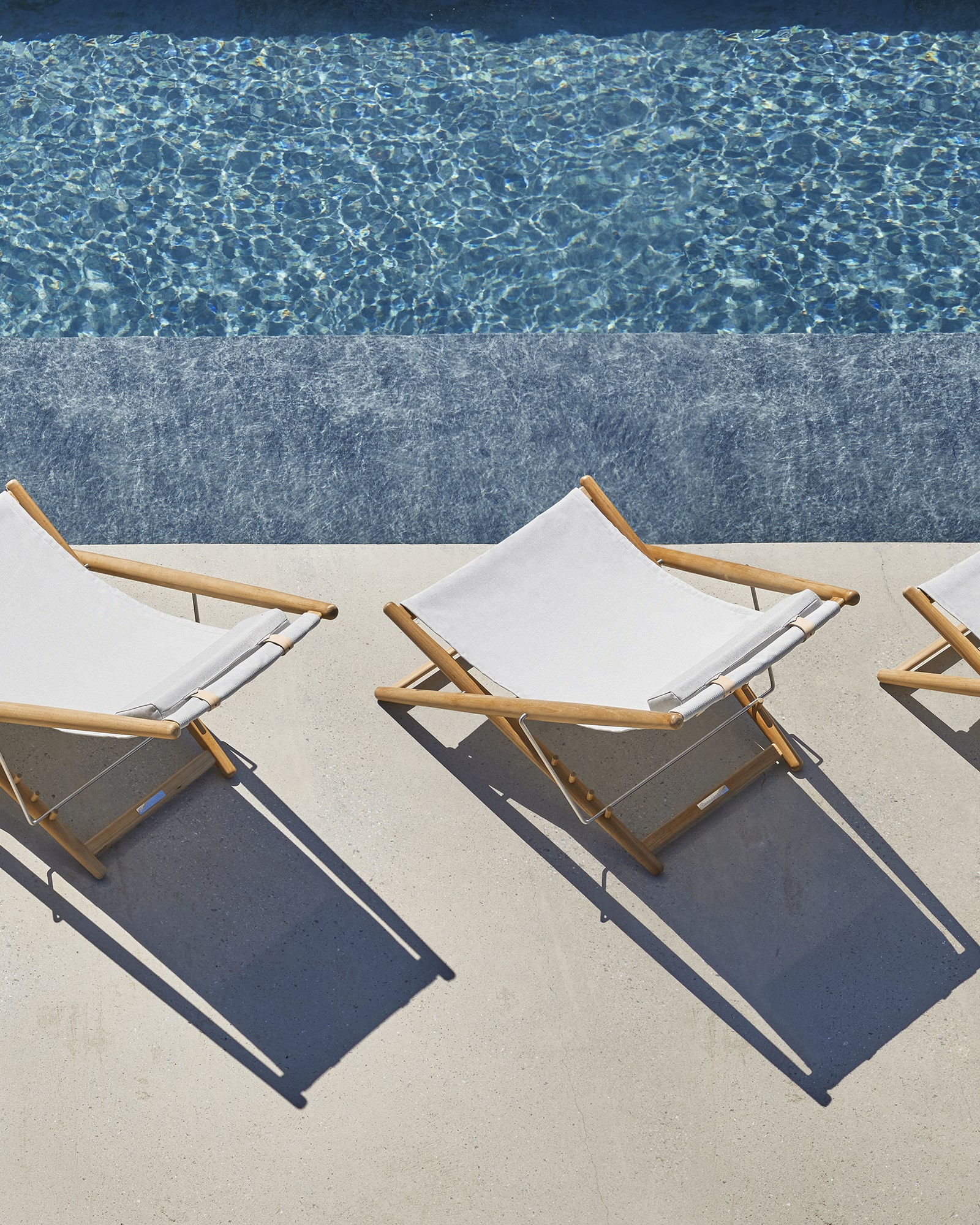 White Skargaarden H55 outdoor lounge chairs by the poolside in a luxury hospitality setting represented by Terentti