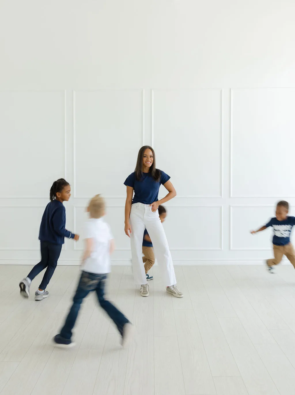 Children running around the main nanny in a room.