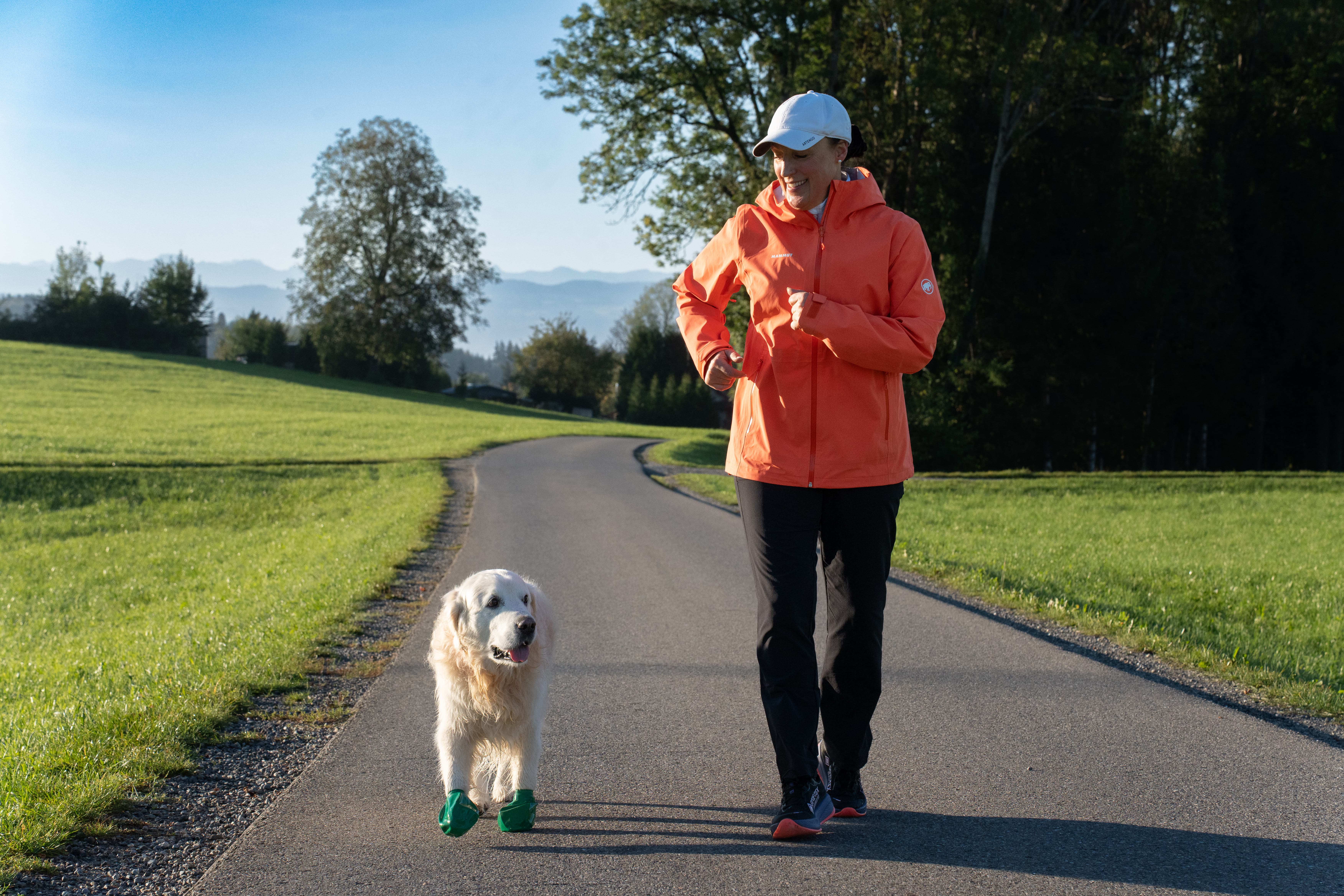 Doris und Jacky von vorne, zueinander schauend vor grüner Landschaft mit Bergkulisse.