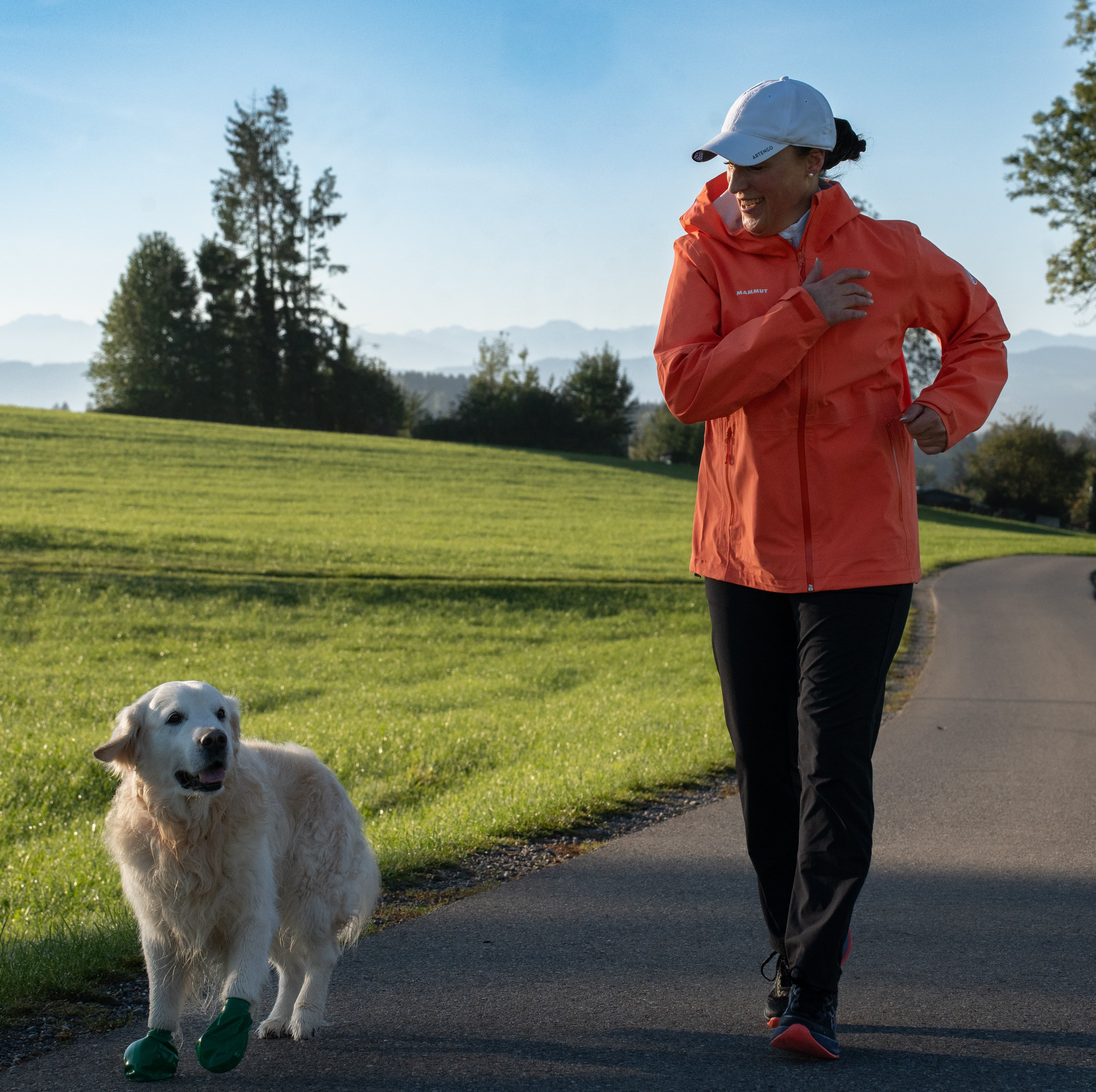 Doris und Jacky von vorne beim Bajoli-Lauf mit Blickrichtung zueinander vor Wiesen und Bergkulisse.