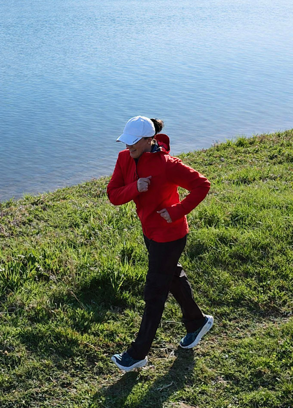 Doris beim Bajoli-Lauf auf einer Wiese vor einem See bei Sonnenschein..
