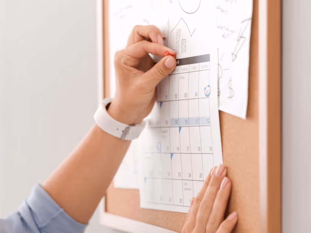 Frau hakt am Wandkalender ihre Routinen ab